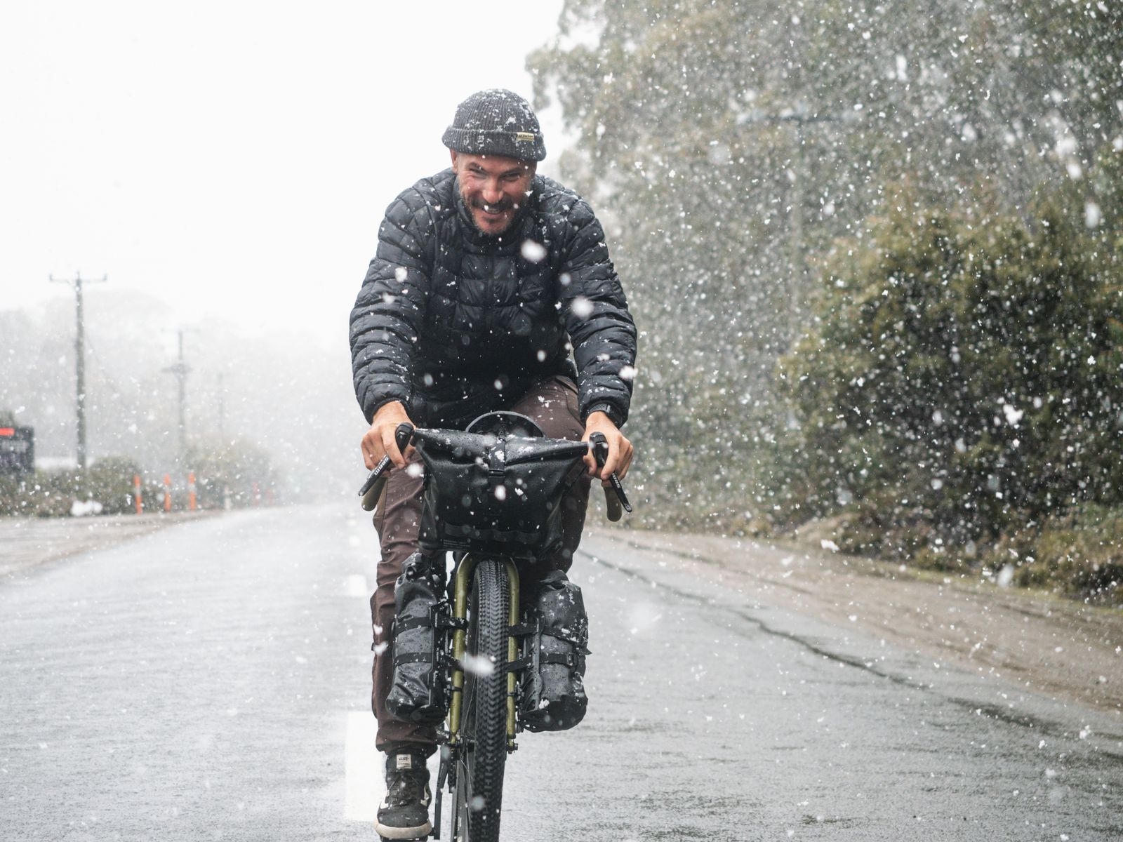 Riding a loaded gravel bike through a snowstorm near Derwent Bridge, Tasmania